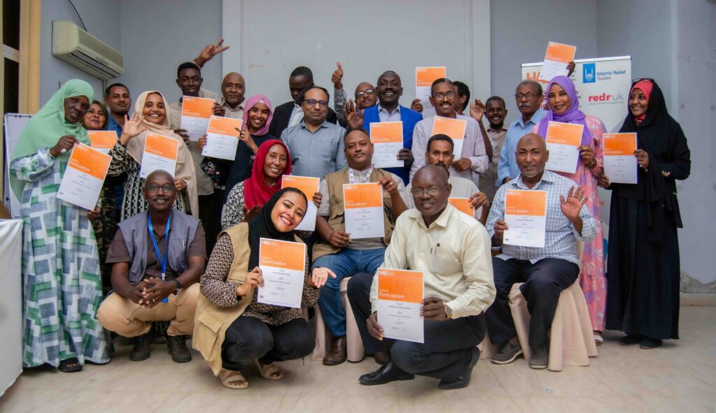 Participants holding their orange completion certificates